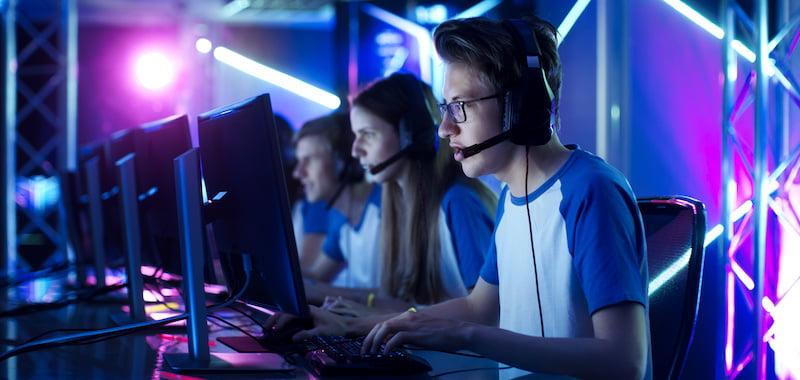 Team of Teenage Gamers Play in Multiplayer PC Video Game on a eSport Tournament. Captain Gives Commands into Microphone, Trying Strategically Win the Game.